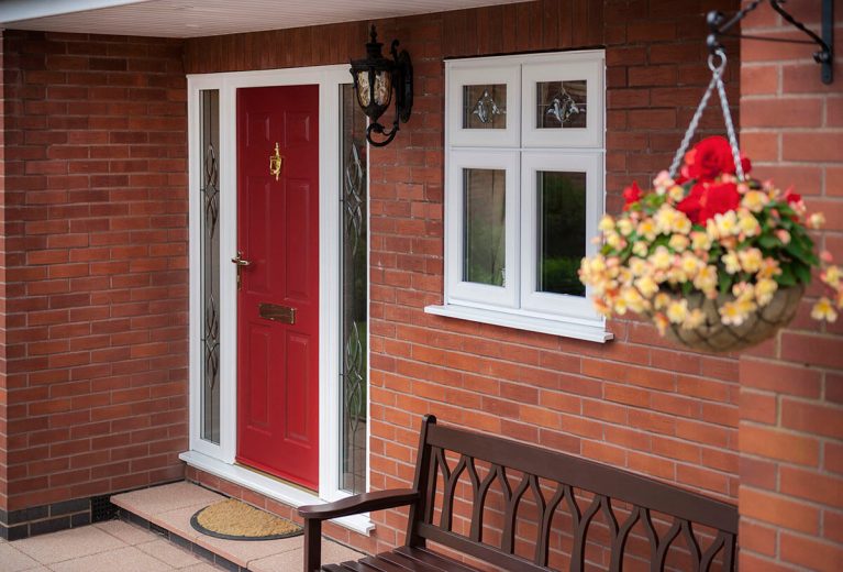 Red UPVC door with golden knocker.