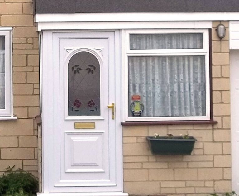 White UPVC entrance door with rose leading.