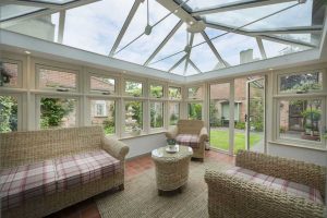 Am interior photo of a conservatory with a glass roof and double glazed windows and doors